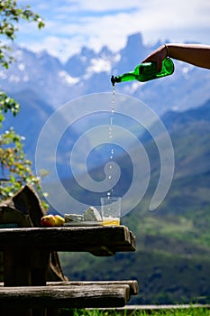 Pouring from high height of natural Asturian cider made fromÂ fermented apples, Asturian cabrales cow blue cheese with view on